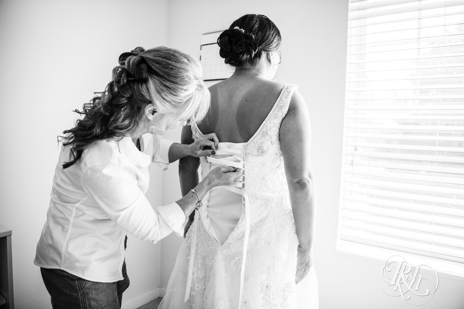 Mom lacing corset on wedding dress.