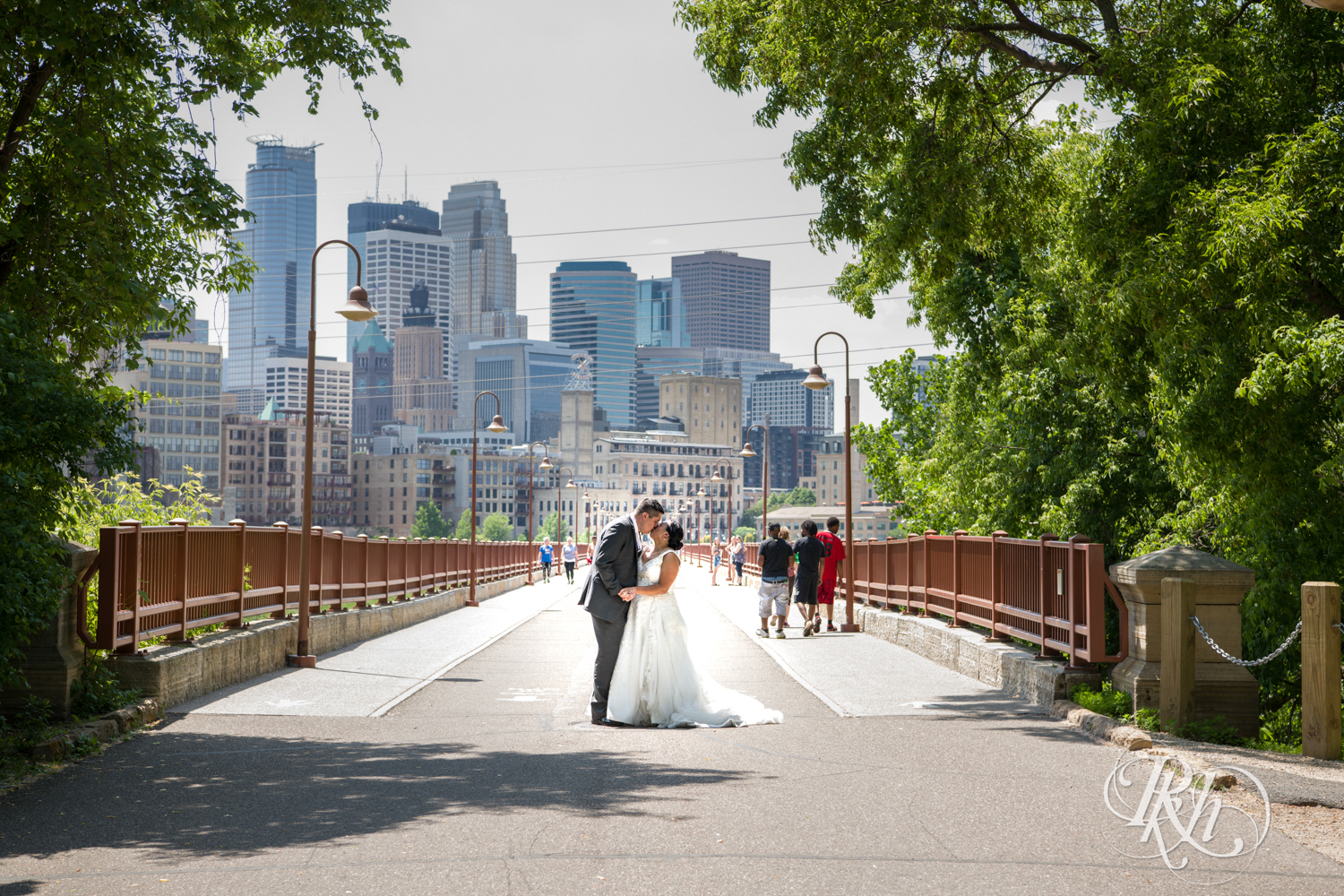 Bride and groom kiss on the Stone Arch Bridge in Minneapolis, Minnesota.