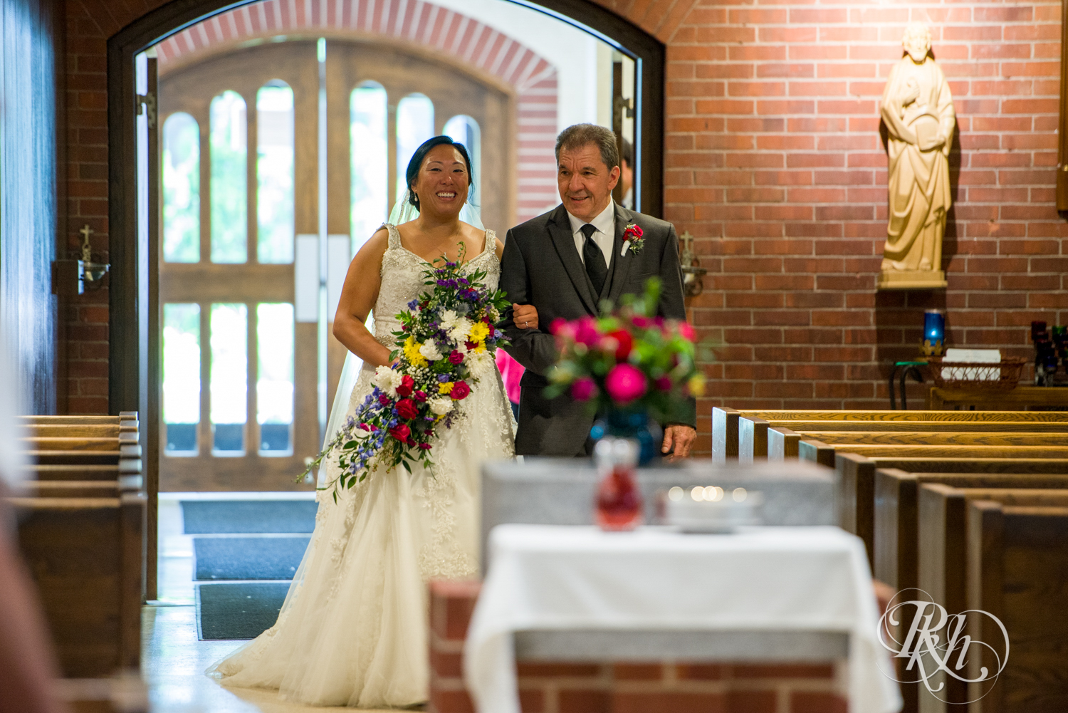 Bride and dad walk down the aisle in church wedding in Minneapolis, Minnesota.