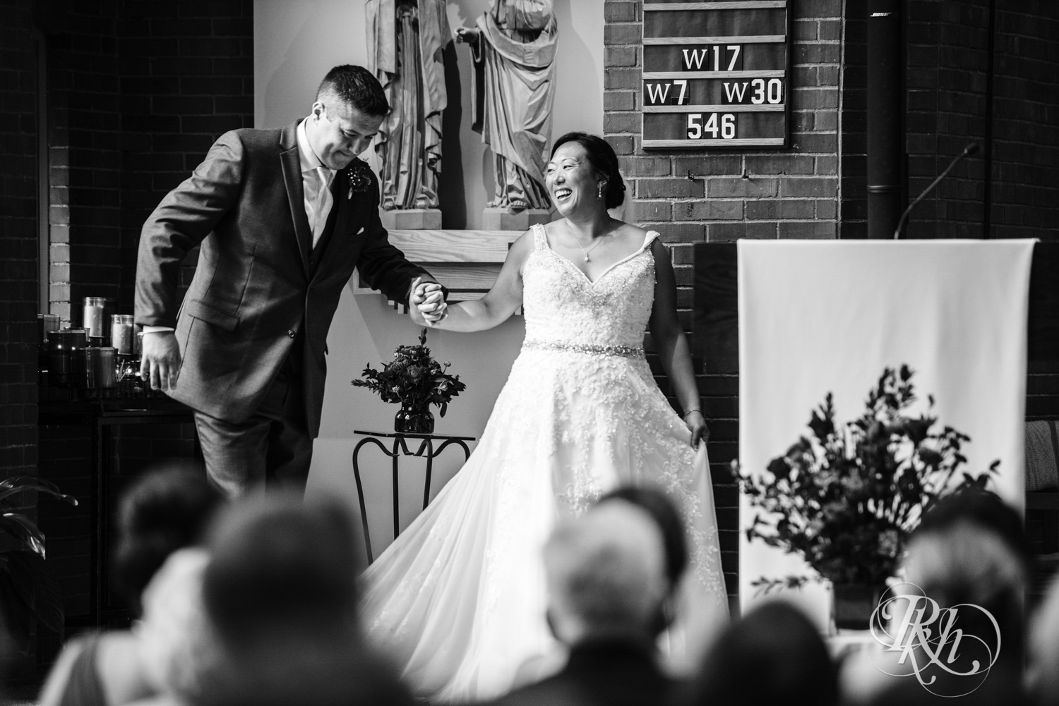 Bride and groom smile during church wedding ceremony in Minneapolis, Minnesota.