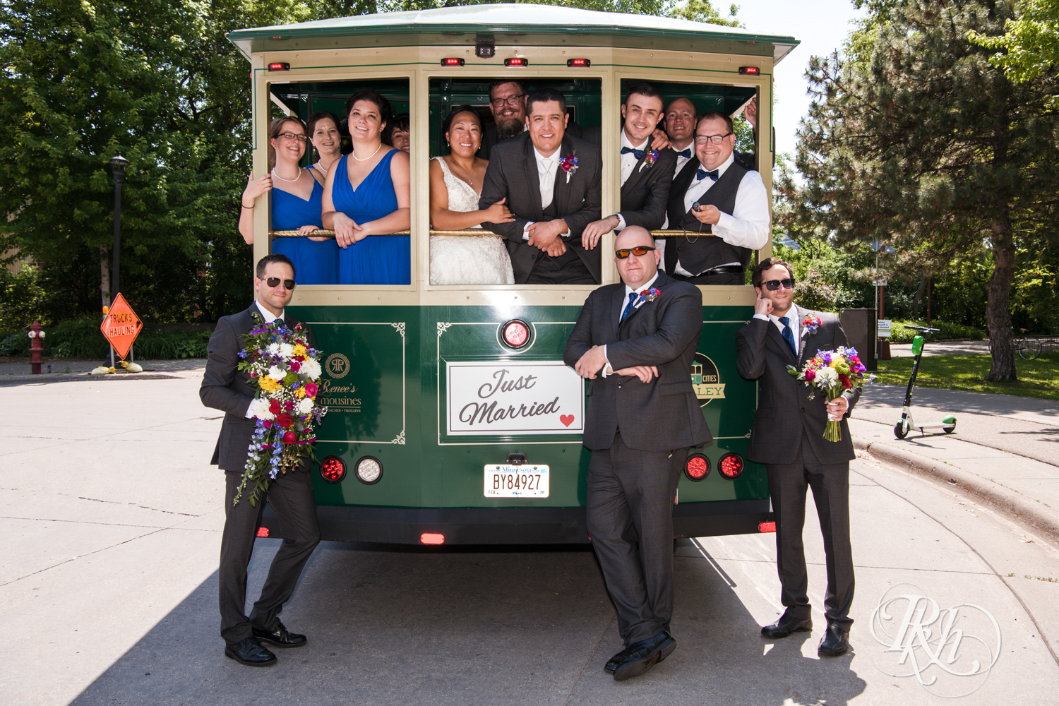 Wedding party smiles and laughs on trolley at the University of Minnesota in Minneapolis, Minnesota.