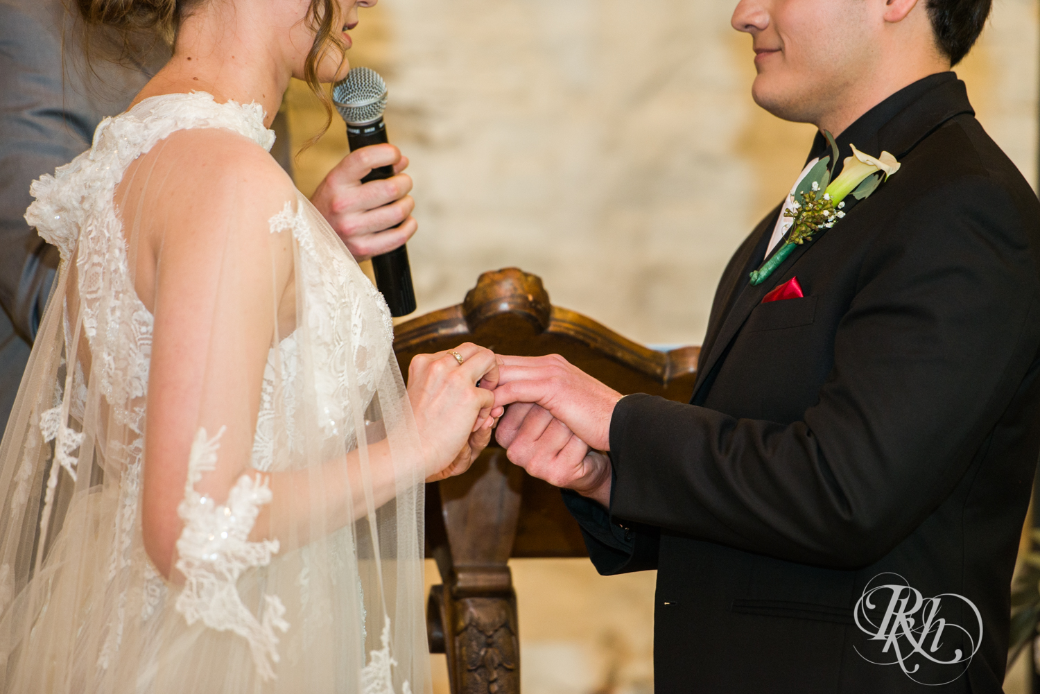 Bride and groom exchange rings at wedding ceremony at Kellerman's Event Center in White Bear Lake, Minnesota.