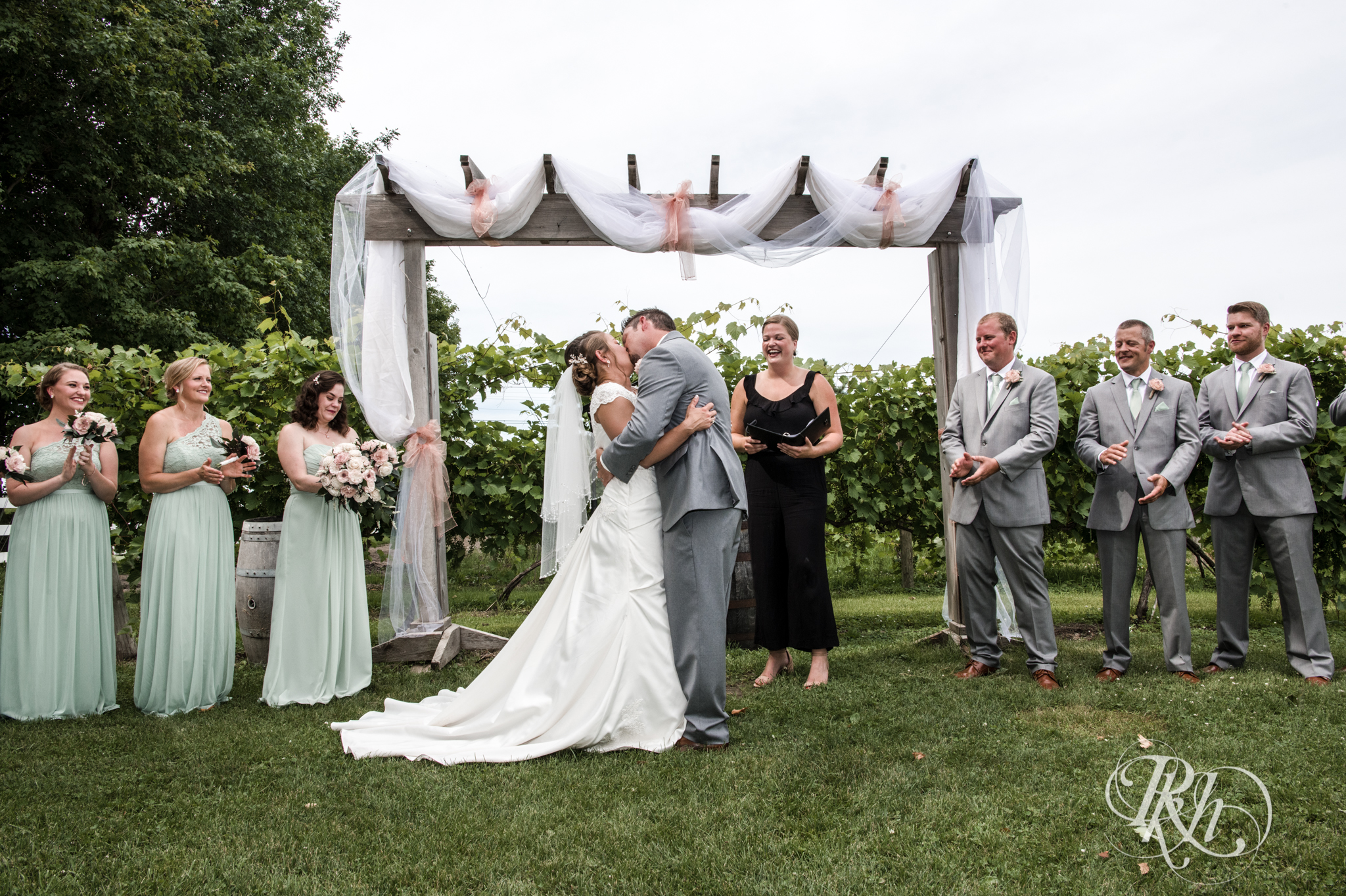 Bride and groom kissing during wedding ceremony at Next Chapter Winery in New Prague, Minnesota.