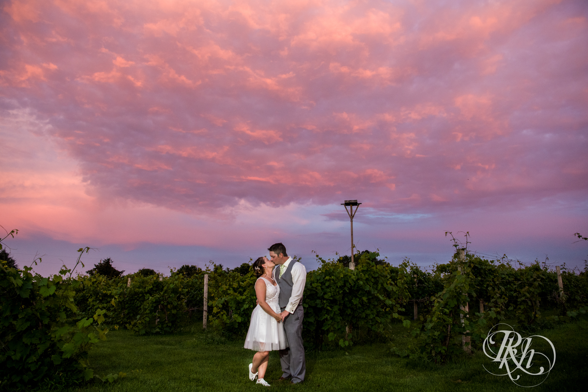 Bride and groom kissing during beautiful sunset at Next Chapter Winery in New Prague, Minnesota.