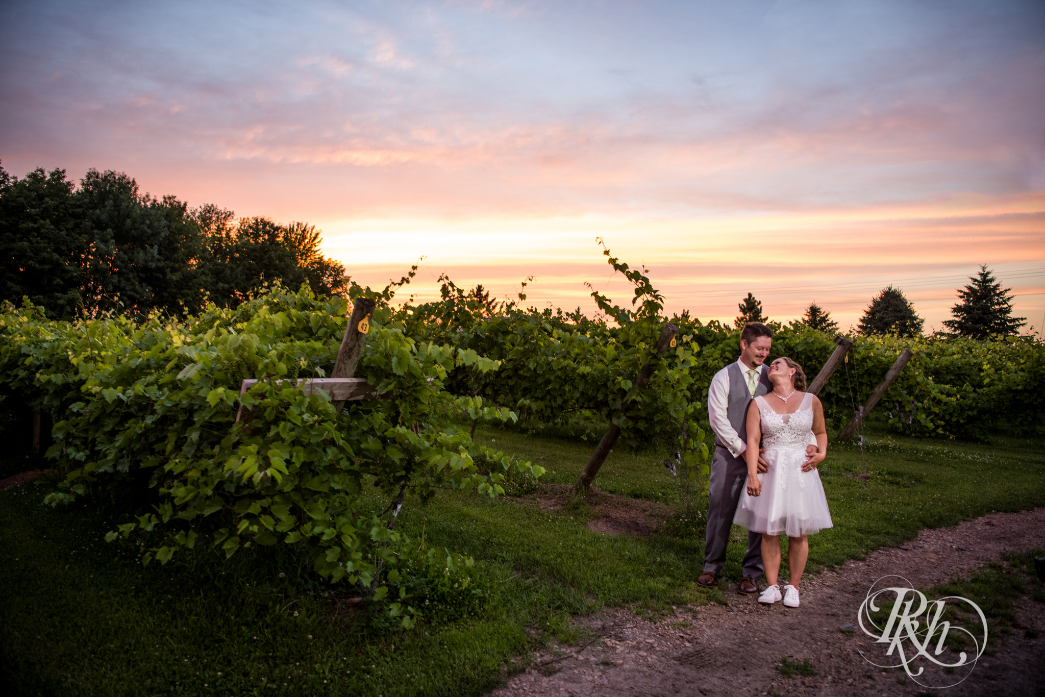 Bride and groom kissing during beautiful sunset at Next Chapter Winery in New Prague, Minnesota.