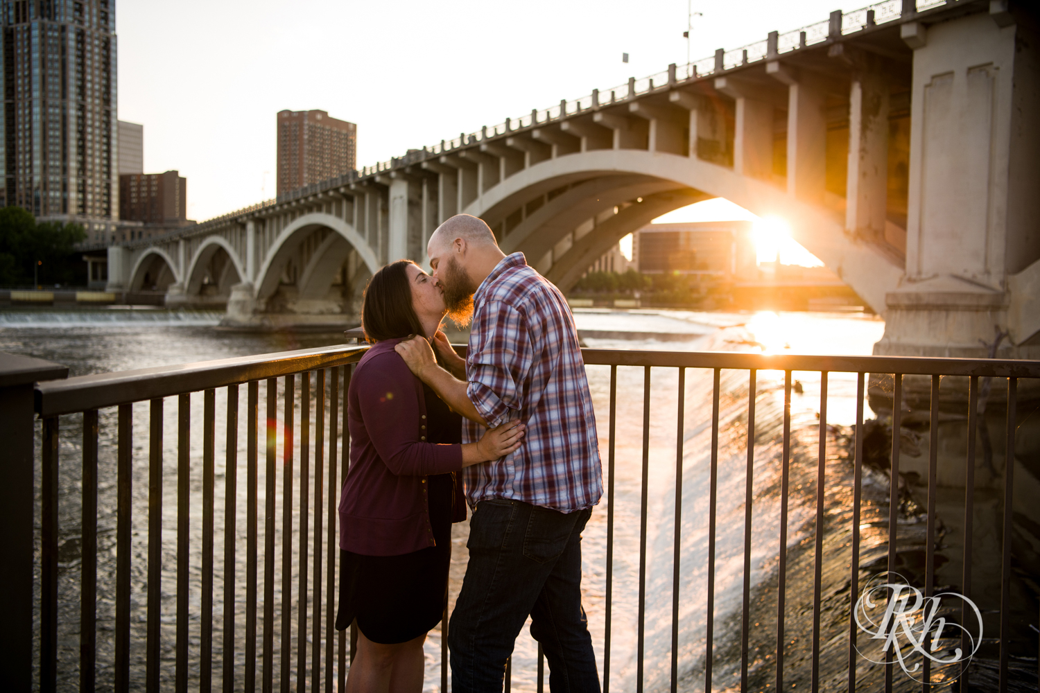 Man and woman kiss in Saint Anthony Main in Minneapolis, Minnesota at sunset.