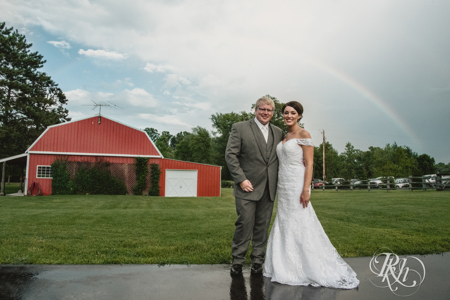 Bride and groom smile under rainbow at Creekside Farm Weddings and Events in Rush City, Minnesota.
