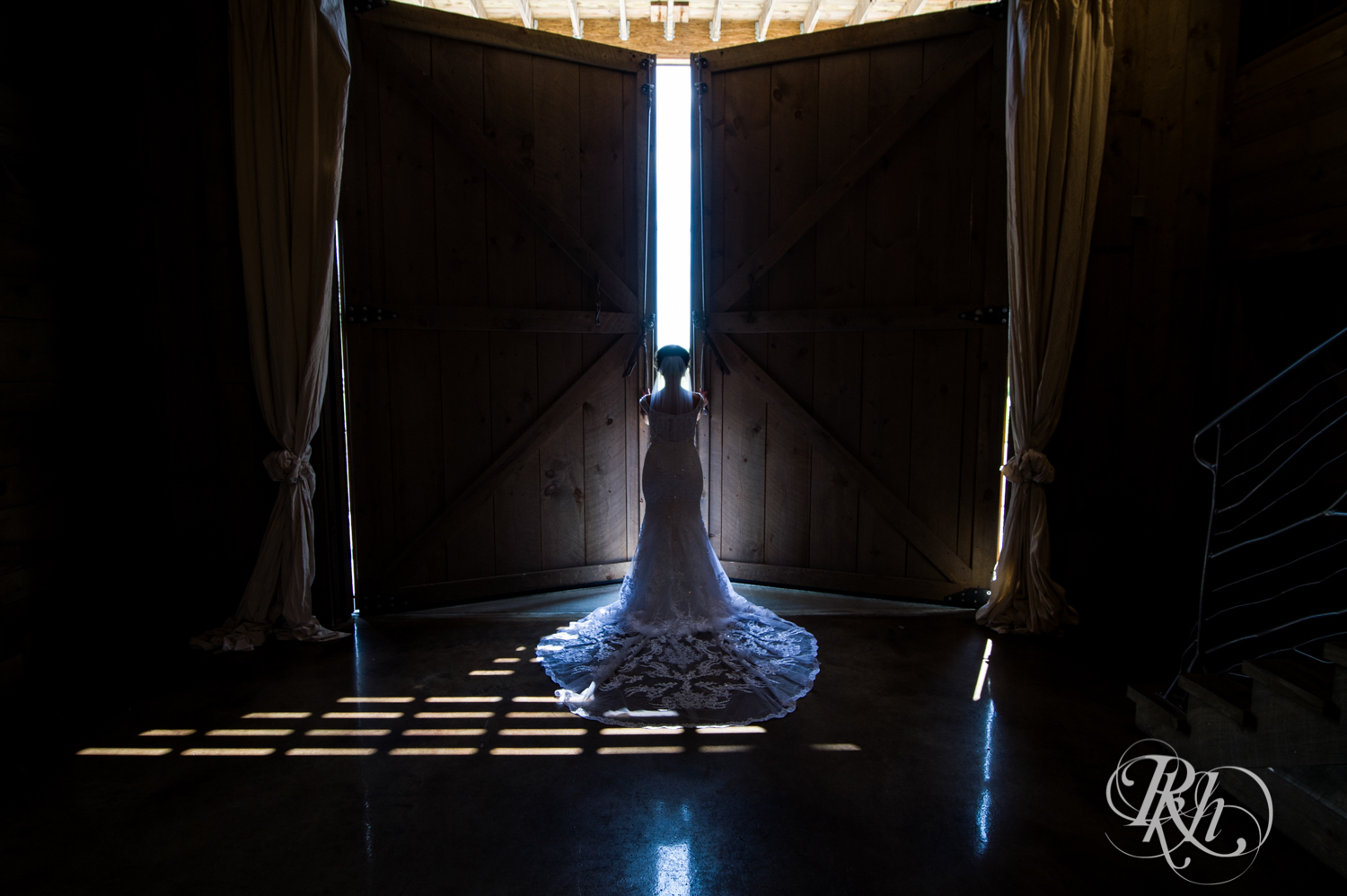 Bride opening barn doors at barn wedding