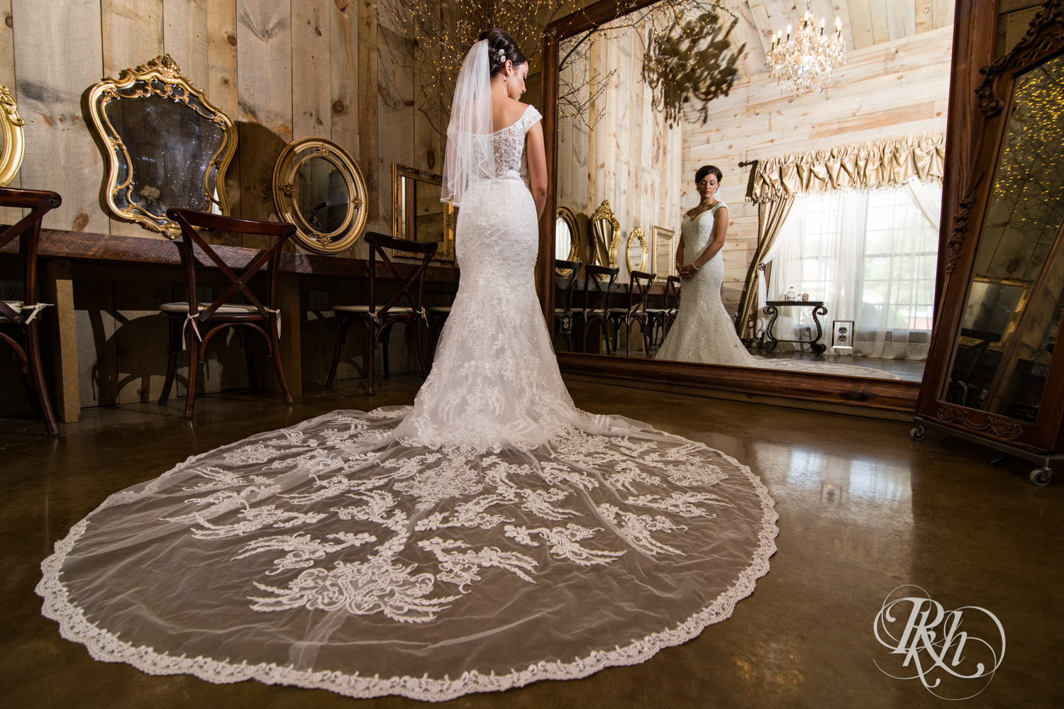 Bride stands in front of mirror at Creekside Farm Weddings and Events in Rush City, Minnesota.