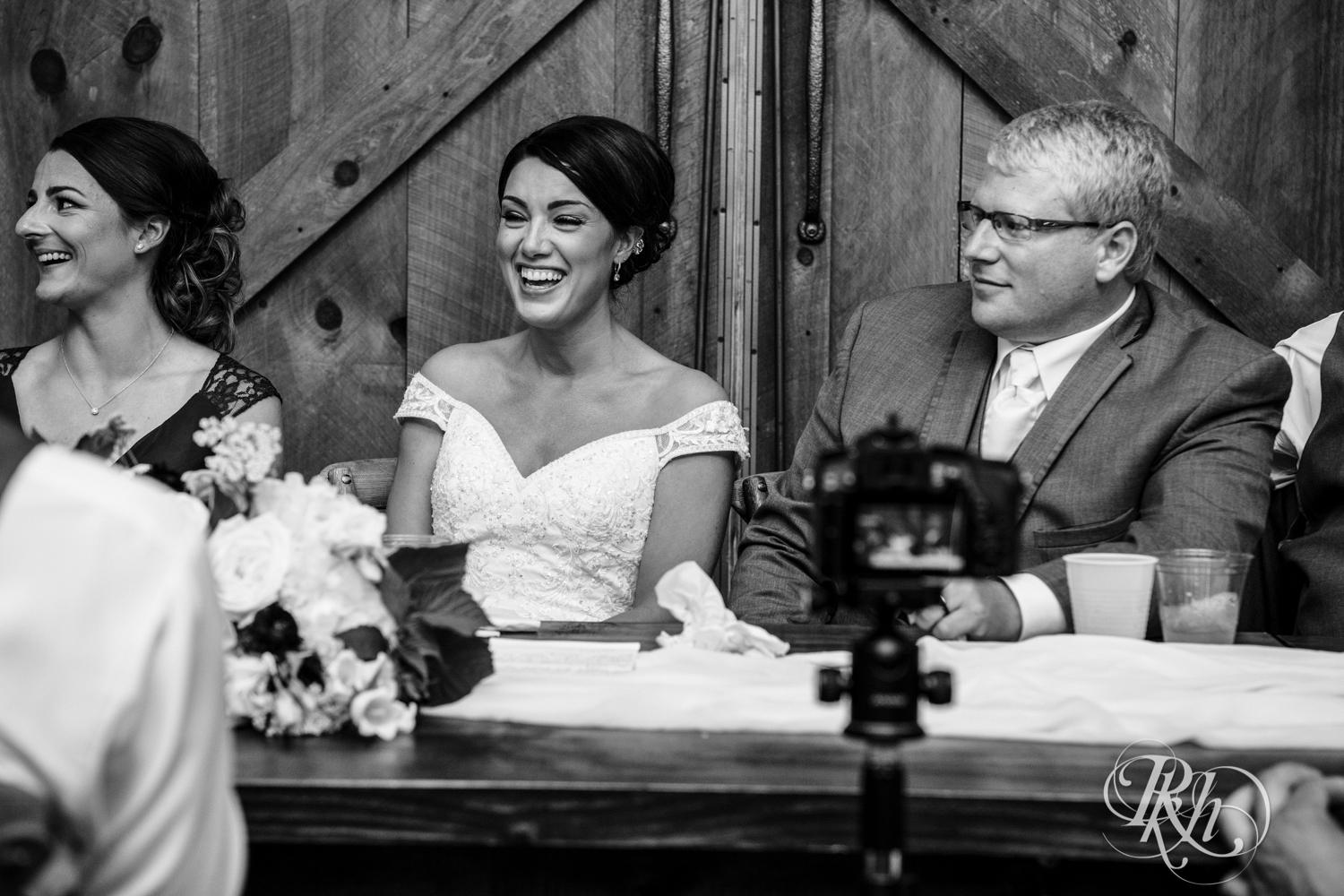Bride and groom laugh during speeches at Creekside Farm Weddings and Events in Rush City, Minnesota.