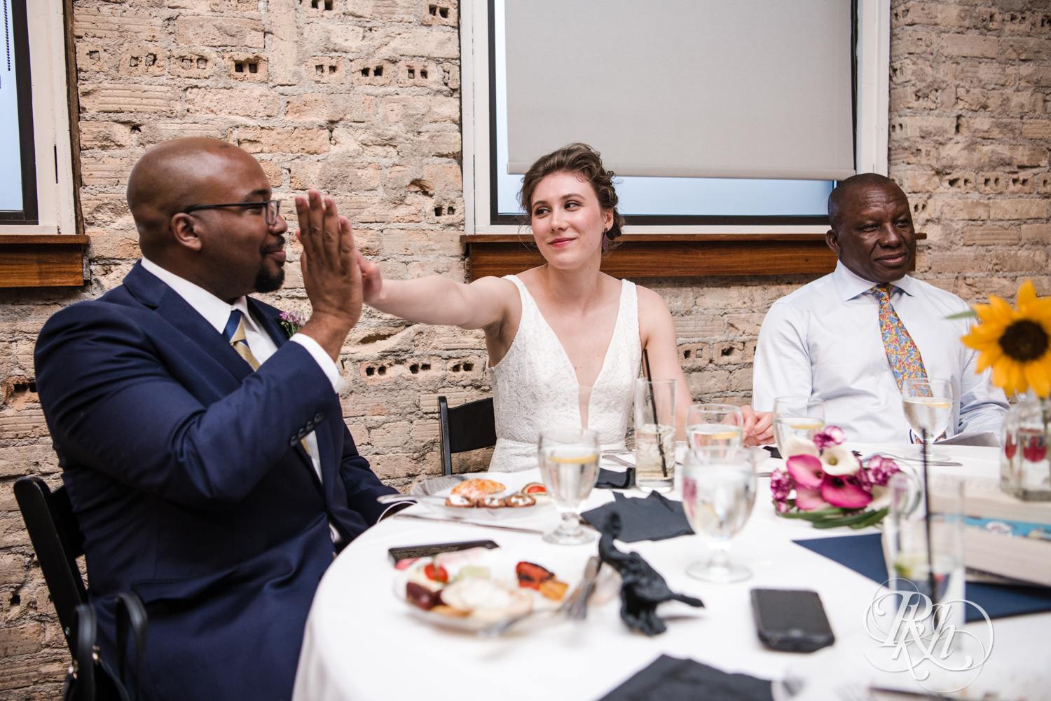 Biracial bride and groom high five during wedding at Five Event Center in Minneapolis, Minnesota.