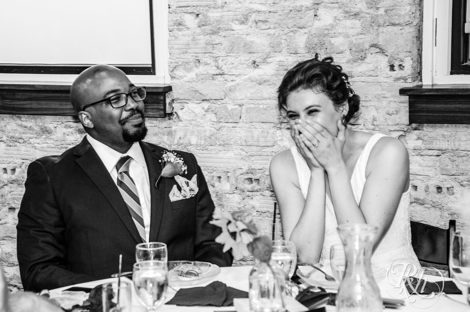 Biracial bride and groom laugh during wedding at Five Event Center in Minneapolis, Minnesota.