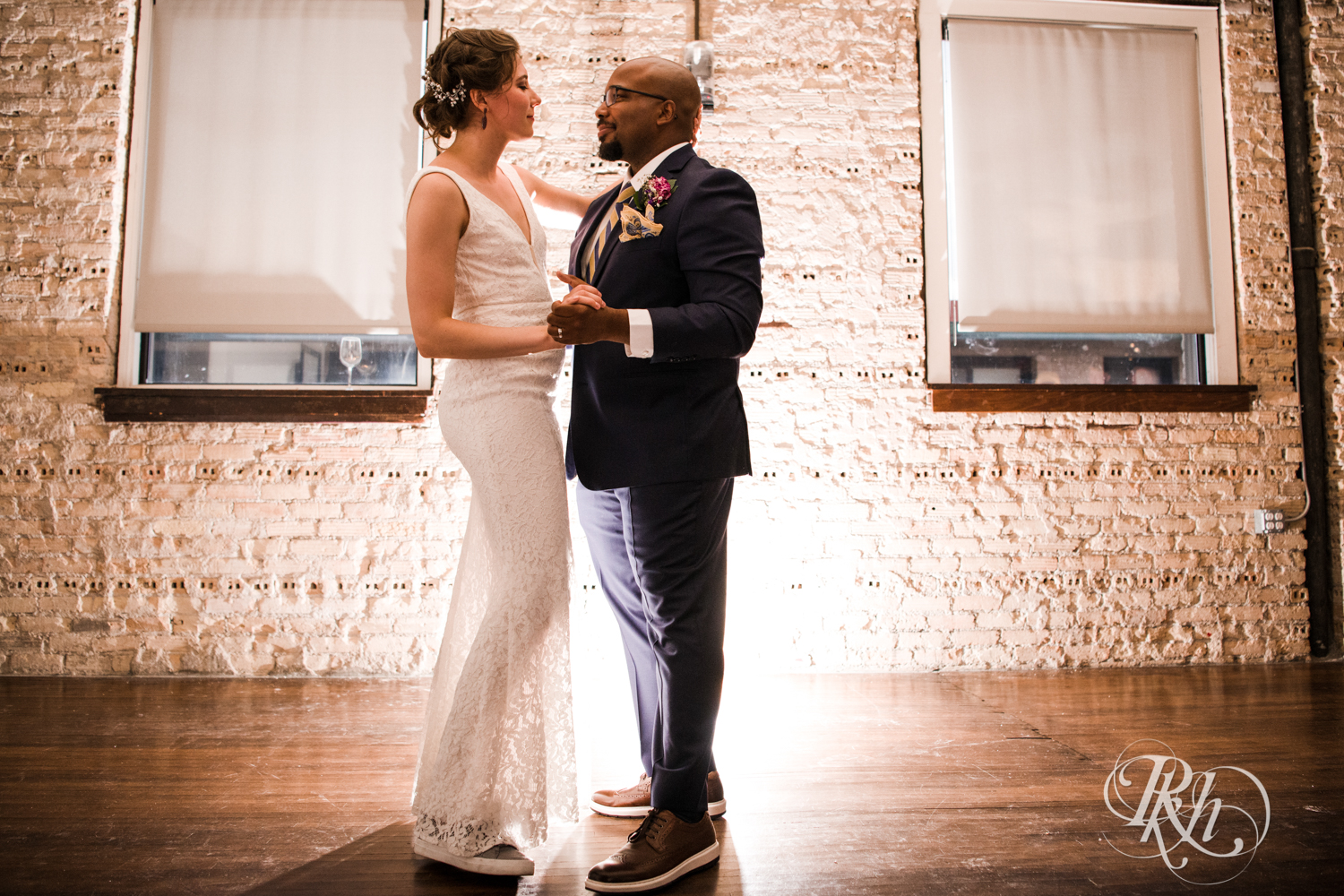 Biracial bride and groom dance during wedding at Five Event Center in Minneapolis, Minnesota.