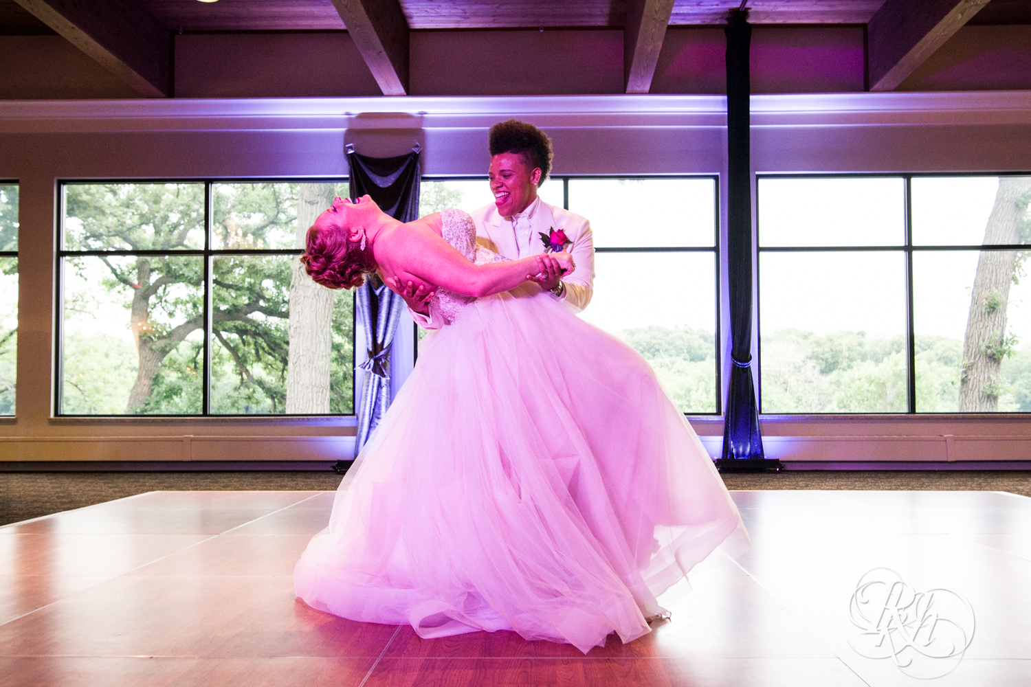 Black lesbian bride and white bride share first dance at Leopold's Mississippi Gardens in Brooklyn Park, Minnesota.
