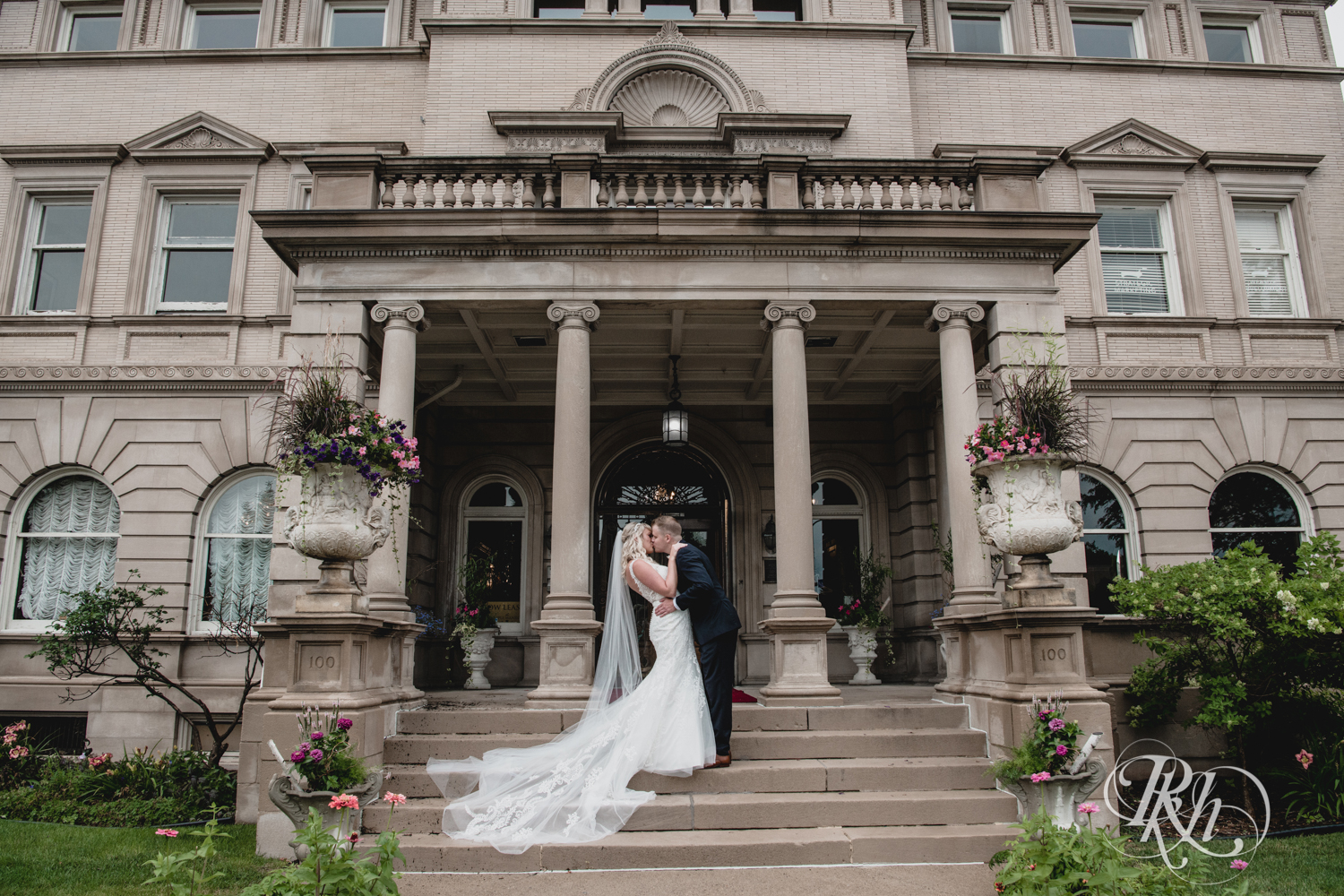 Bride and groom kiss in front of the Semple Mansion in Minneapolis, Minnesota.