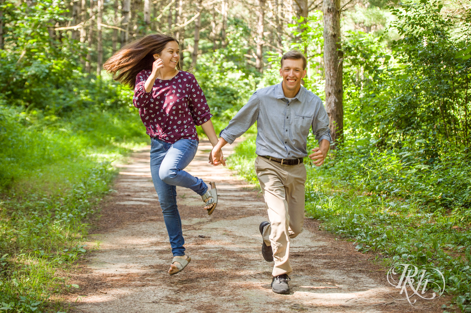 Man in denim and woman in jeans skip at Lebanon Hills Regional Park in Eagan, Minnesota.