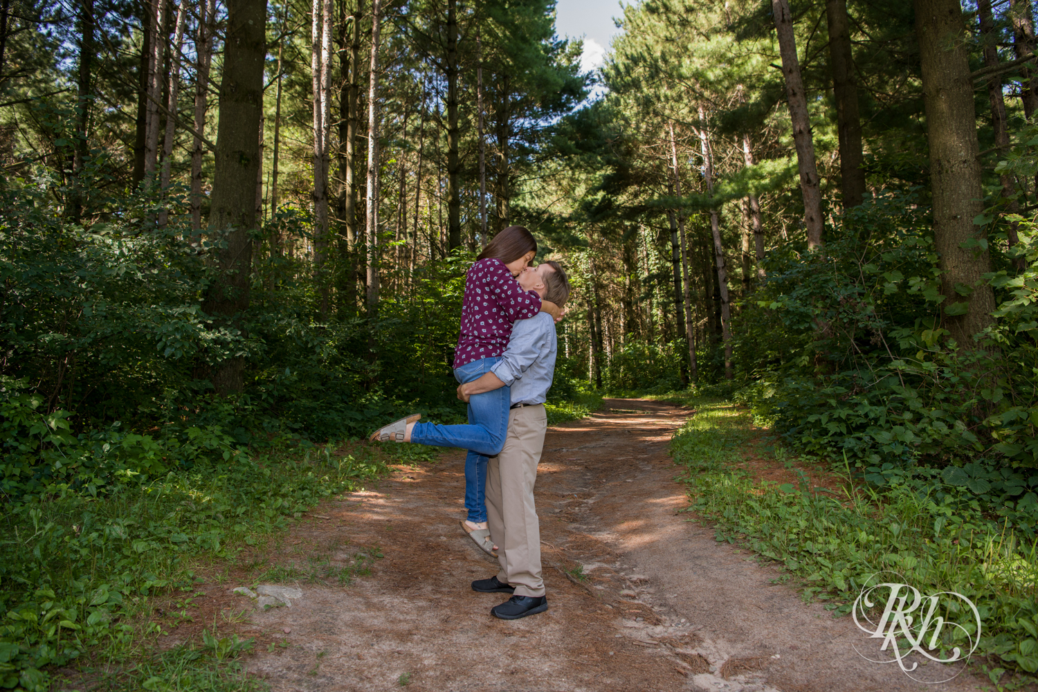 Man and woman kiss in the woods at Lebanon Hills Regional Park in Eagan, Minnesota.
