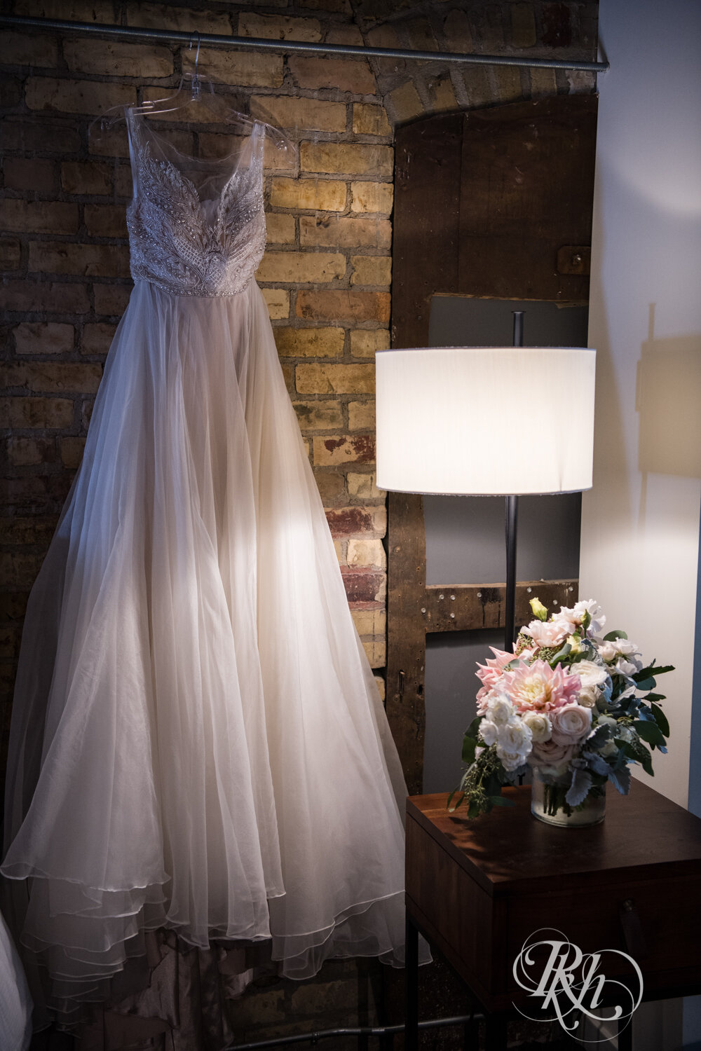 Wedding dress hanging in dramatic lighting at Hewing Hotel in Minneapolis, Minnesota.
