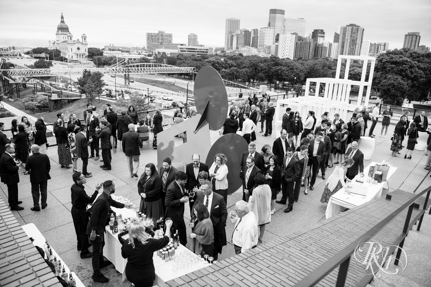 Wedding cocktail hour fills with people on rooftop of Walker Art Center in Minneapolis, Minnesota. 