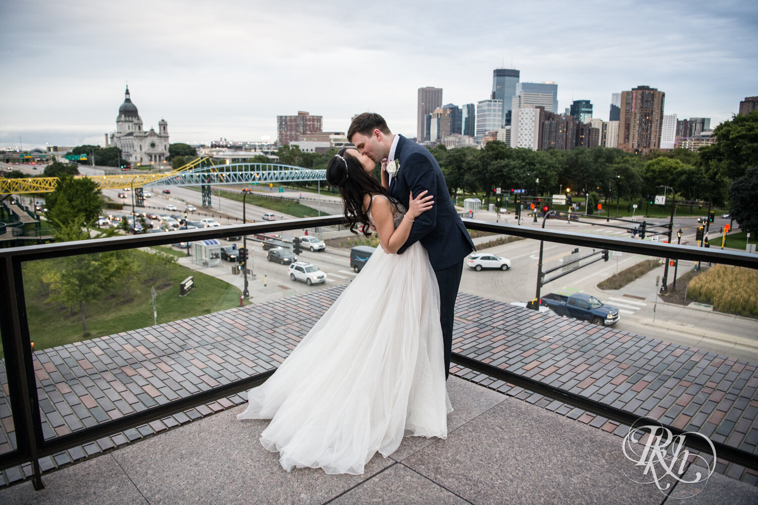 Bride and groom kiss during cocktail hour on rooftop of Walker Art Center in Minneapolis, Minnesota. 