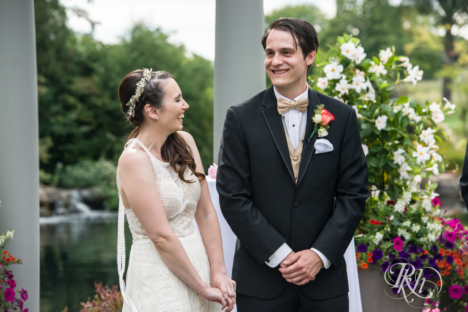 Bride and groom laugh during wedding ceremony at Olympic Hills Golf Club in Eden Prairie, Minnesota.