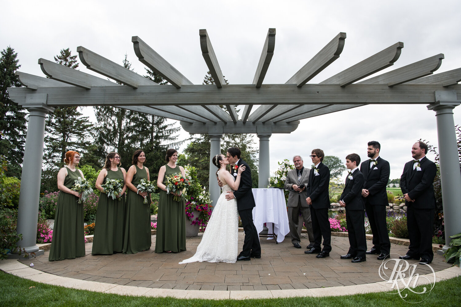 Bride and groom kiss during wedding ceremony at Olympic Hills Golf Club in Eden Prairie, Minnesota.