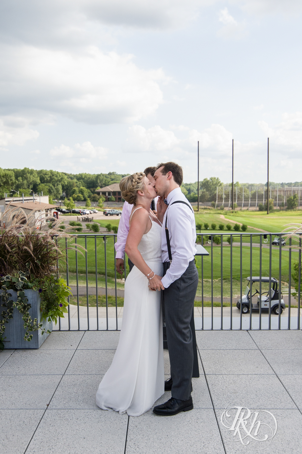 Bride and groom kiss during wedding ceremony at Brookview Golf Course in Golden Valley, Minnesota.