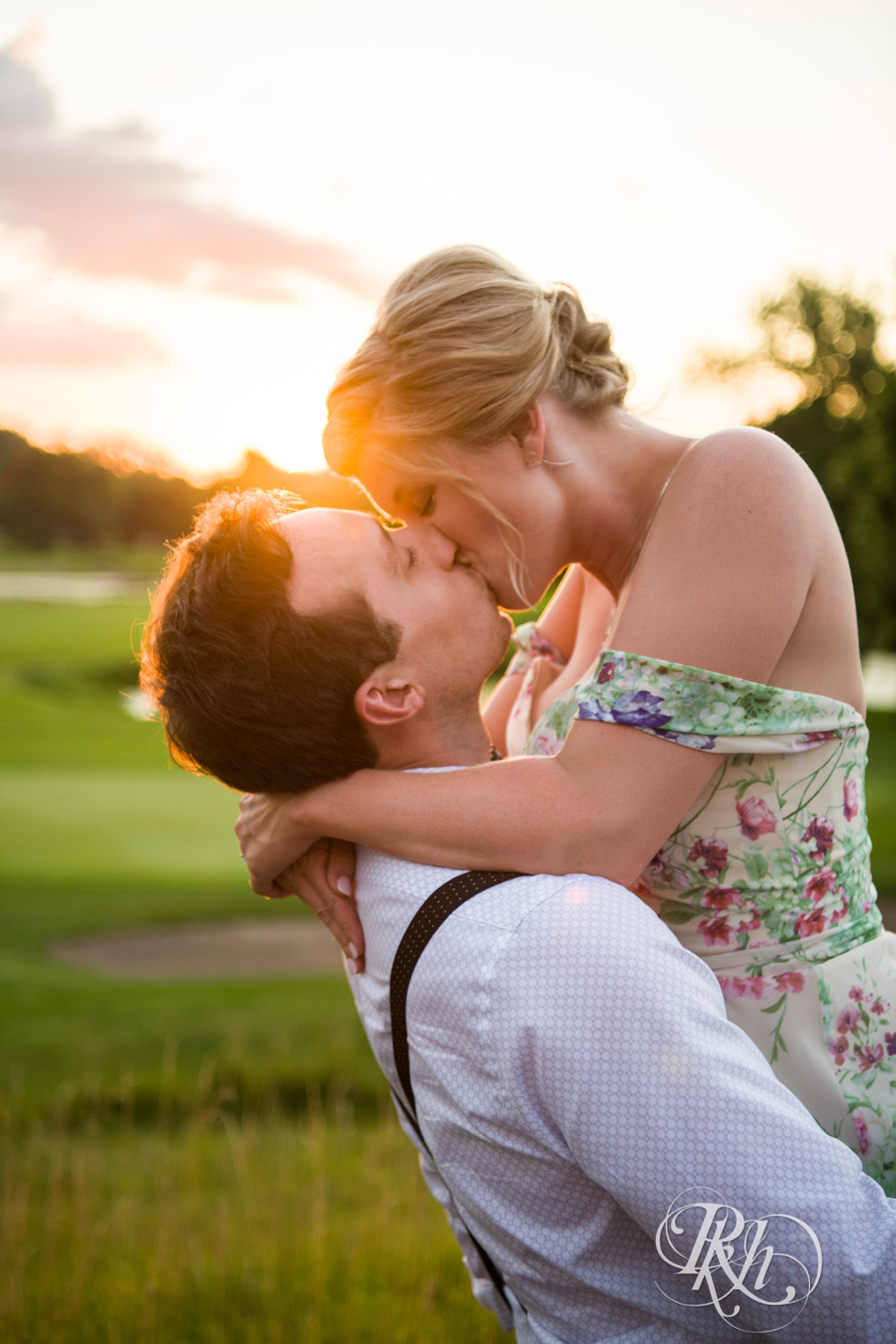 Bride and groom laugh and kiss at sunset at Brookview Golf Course in Golden Valley, Minnesota.