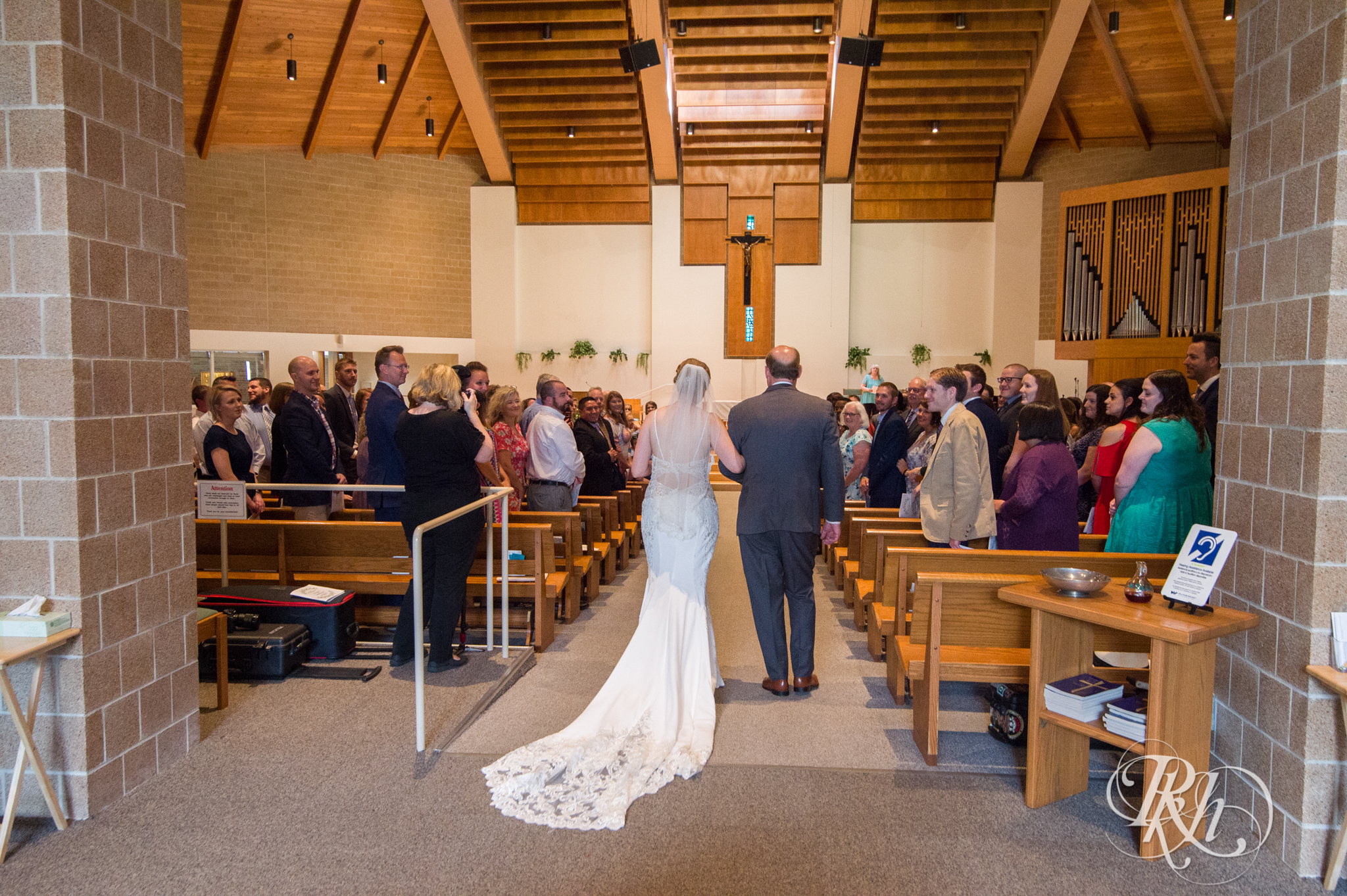 Black walks down the aisle during wedding ceremony at church in Richfield, Minnesota.