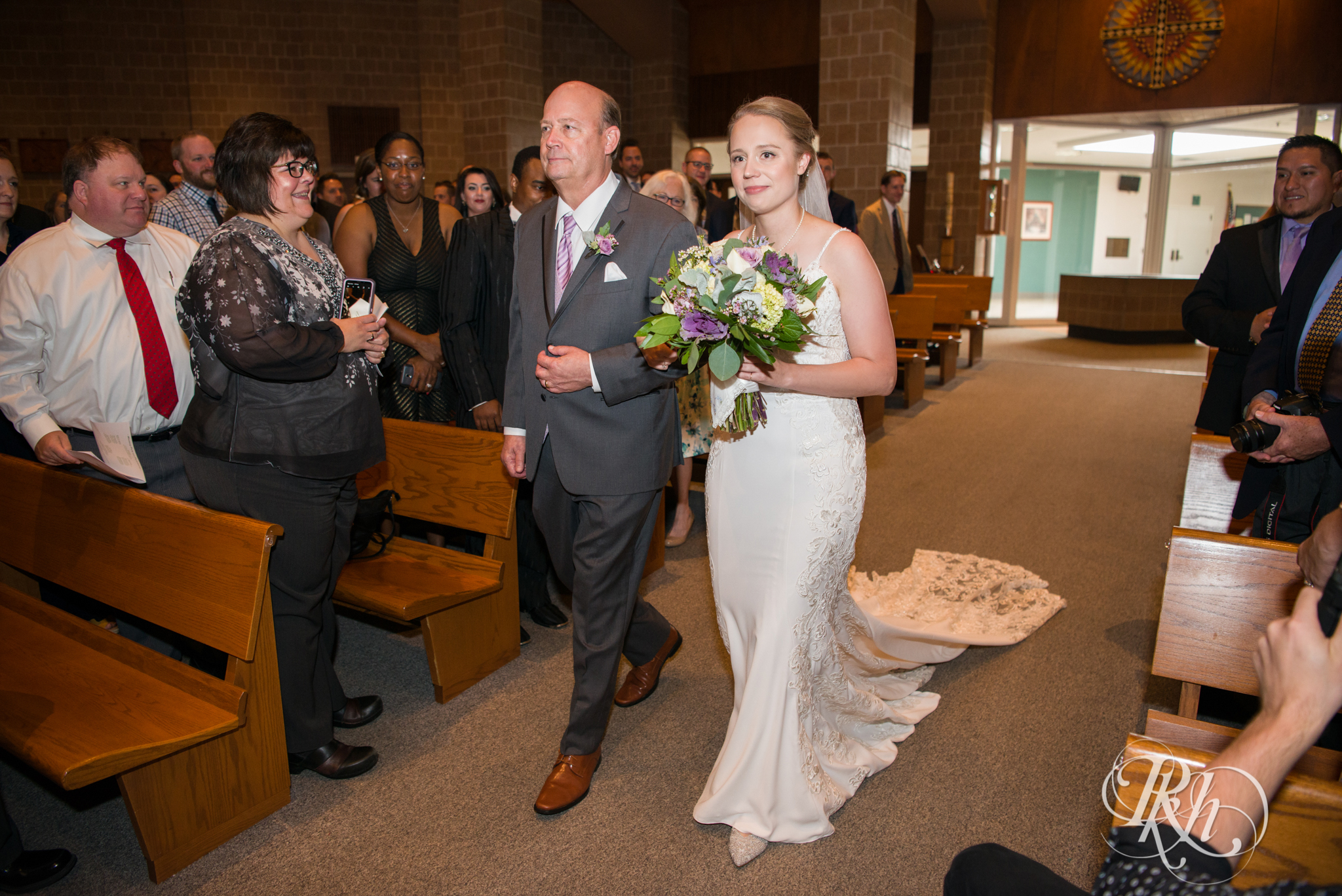 Black walks down the aisle during wedding ceremony at church in Richfield, Minnesota.