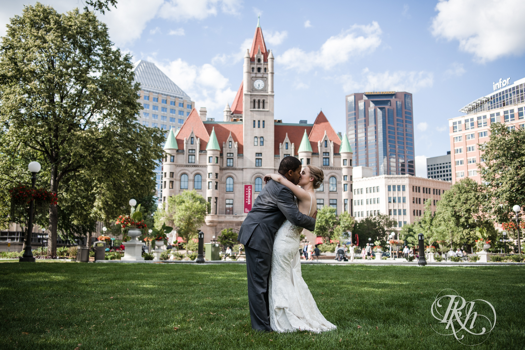 Black groom and white bride kiss in front of Landmark Center in Saint Paul, Minnesota.