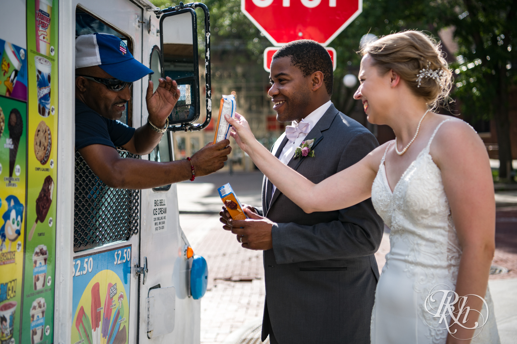 Black groom and white bride buy ice cream from ice cream truck in Saint Paul, Minnesota.