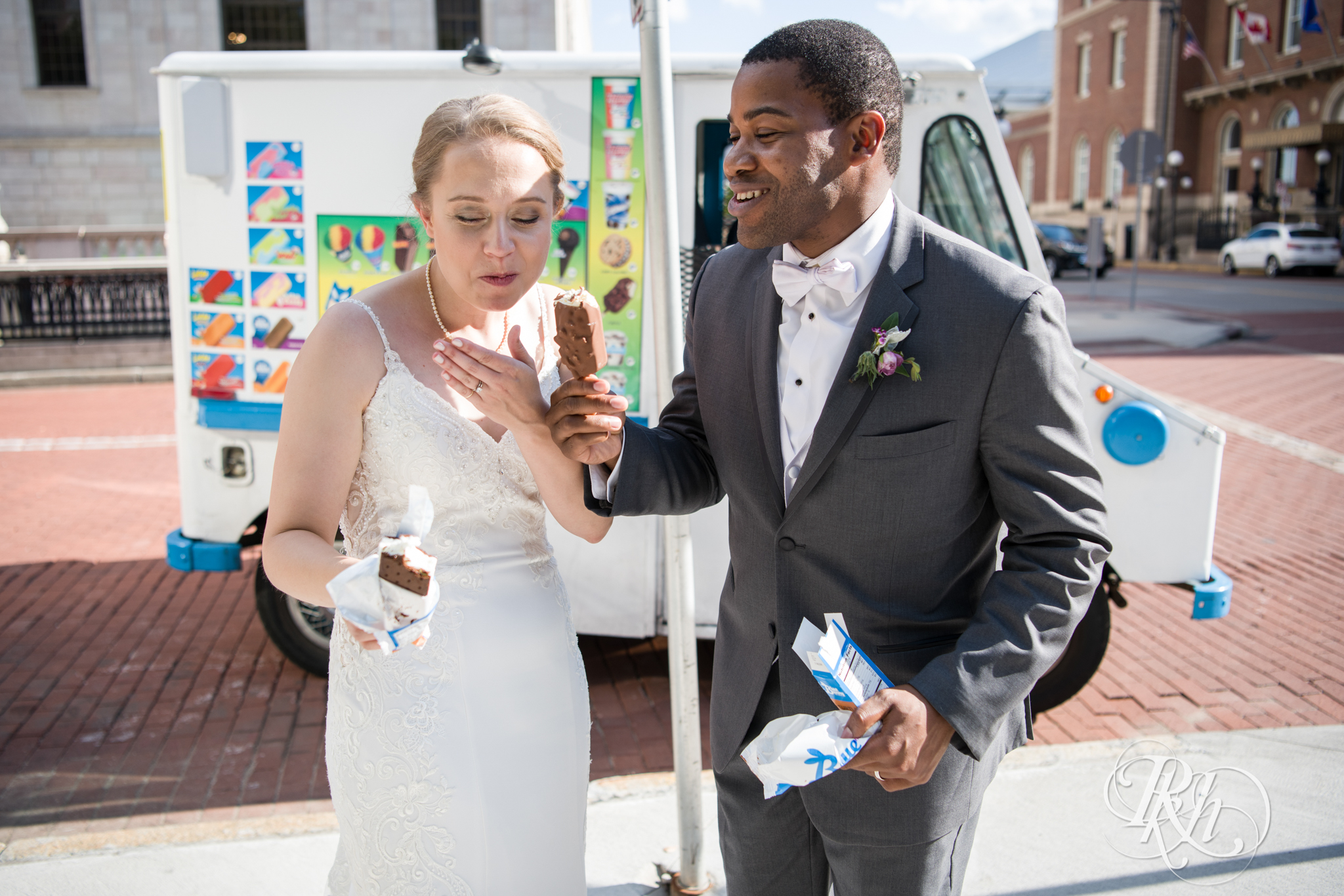 Black groom and white bride buy ice cream from ice cream truck in Saint Paul, Minnesota.