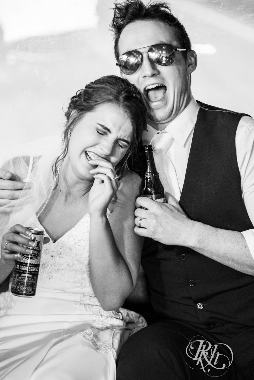 Bride and groom laugh in the back of the party bus in Mankato, Minnesota.