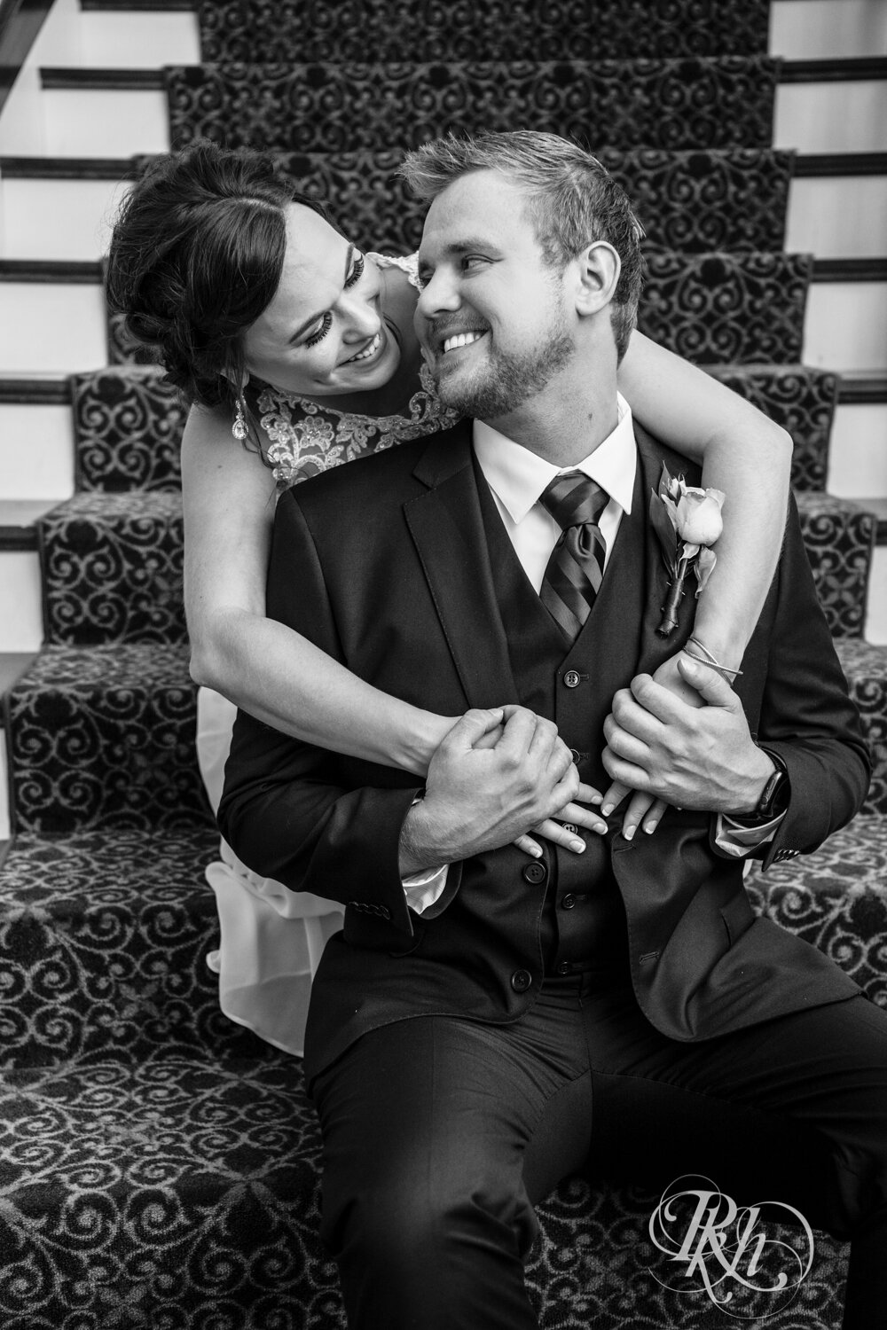Bride and groom smile on stairs at Crown Room in Rogers, Minnesota.