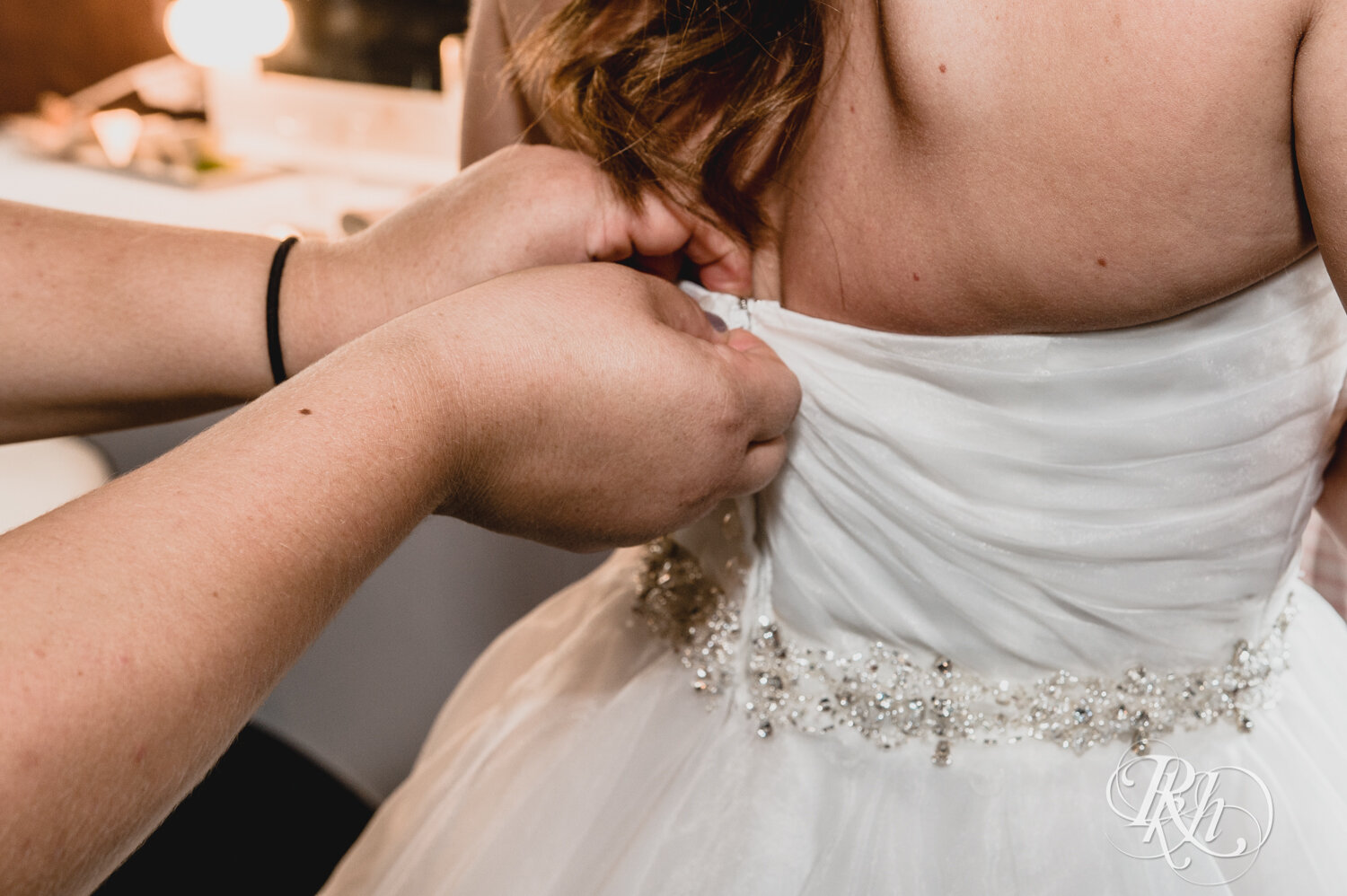 Bride getting wedding dress zipped up at Rockwoods in Otsego, Minnesota.