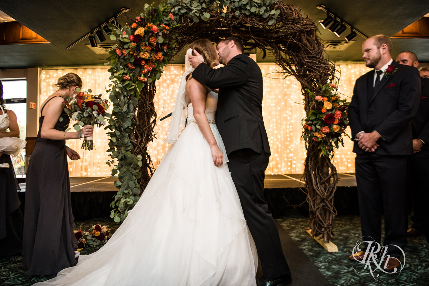 Bride and groom kiss at indoor wedding ceremony at Rockwoods in Otsego, Minnesota.