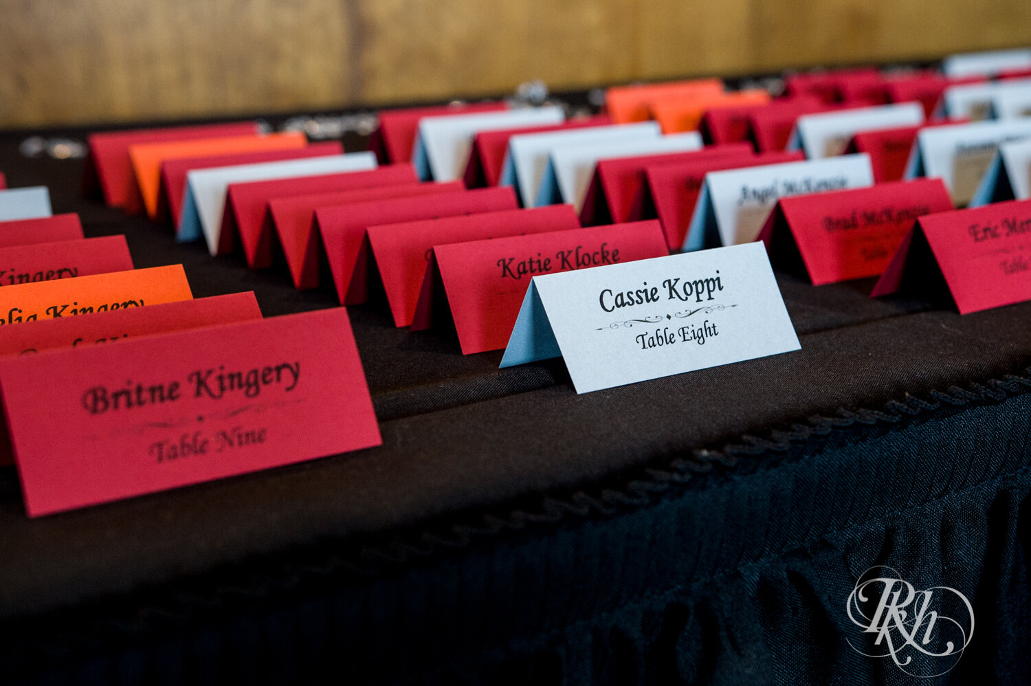 Red, orange, and grey wedding place cards in Rockwoods in Otsego, Minnesota.