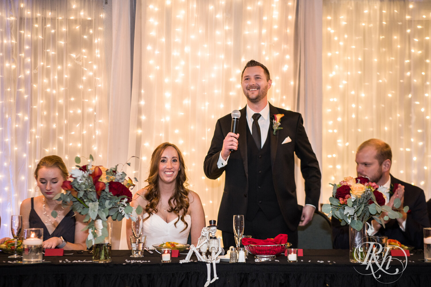 Bride and groom laugh during speeches at wedding reception at Rockwoods in Otsego, Minnesota.