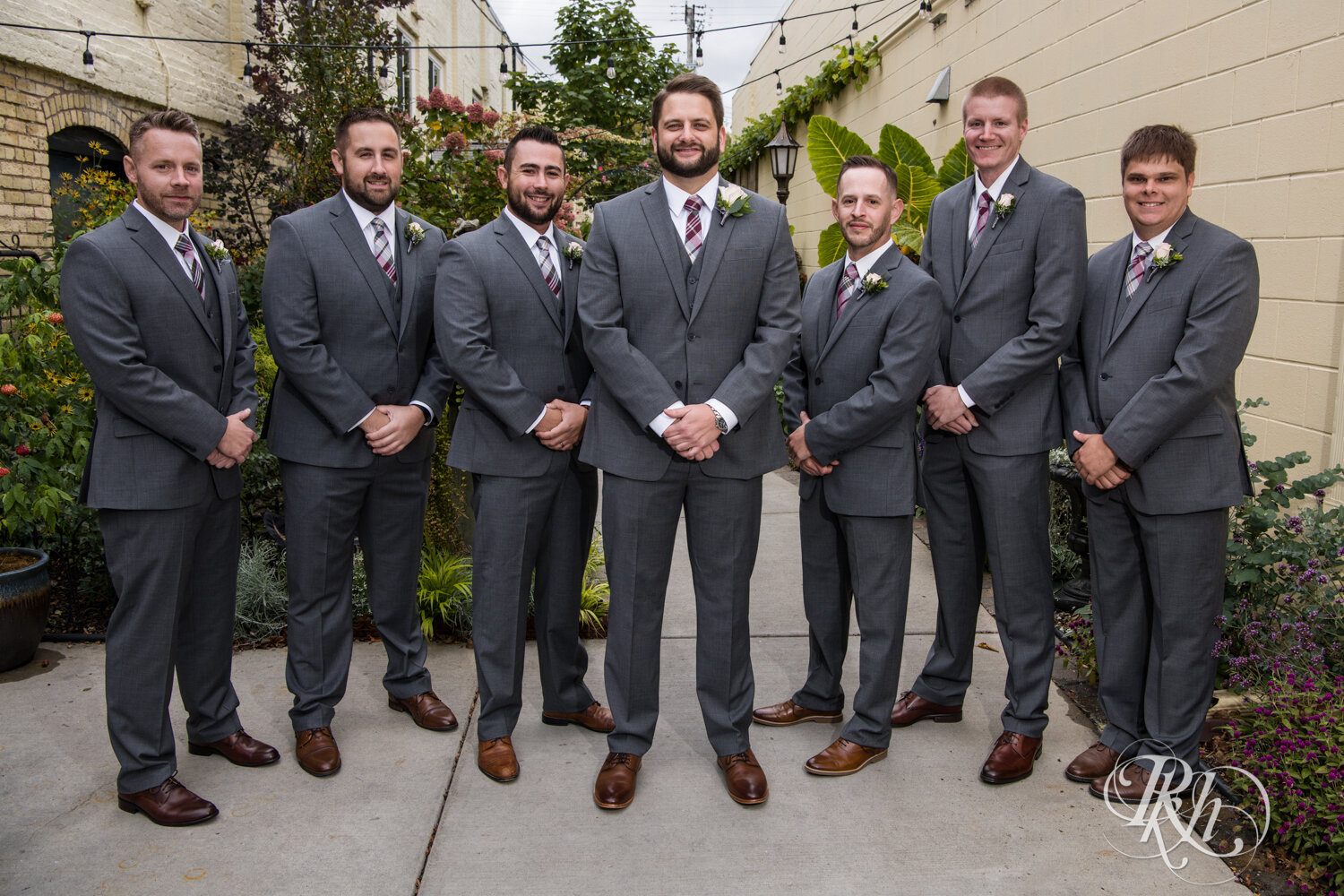 Wedding party in gray suits smile at Kellerman's Event Center in White Bear Lake, Minnesota.