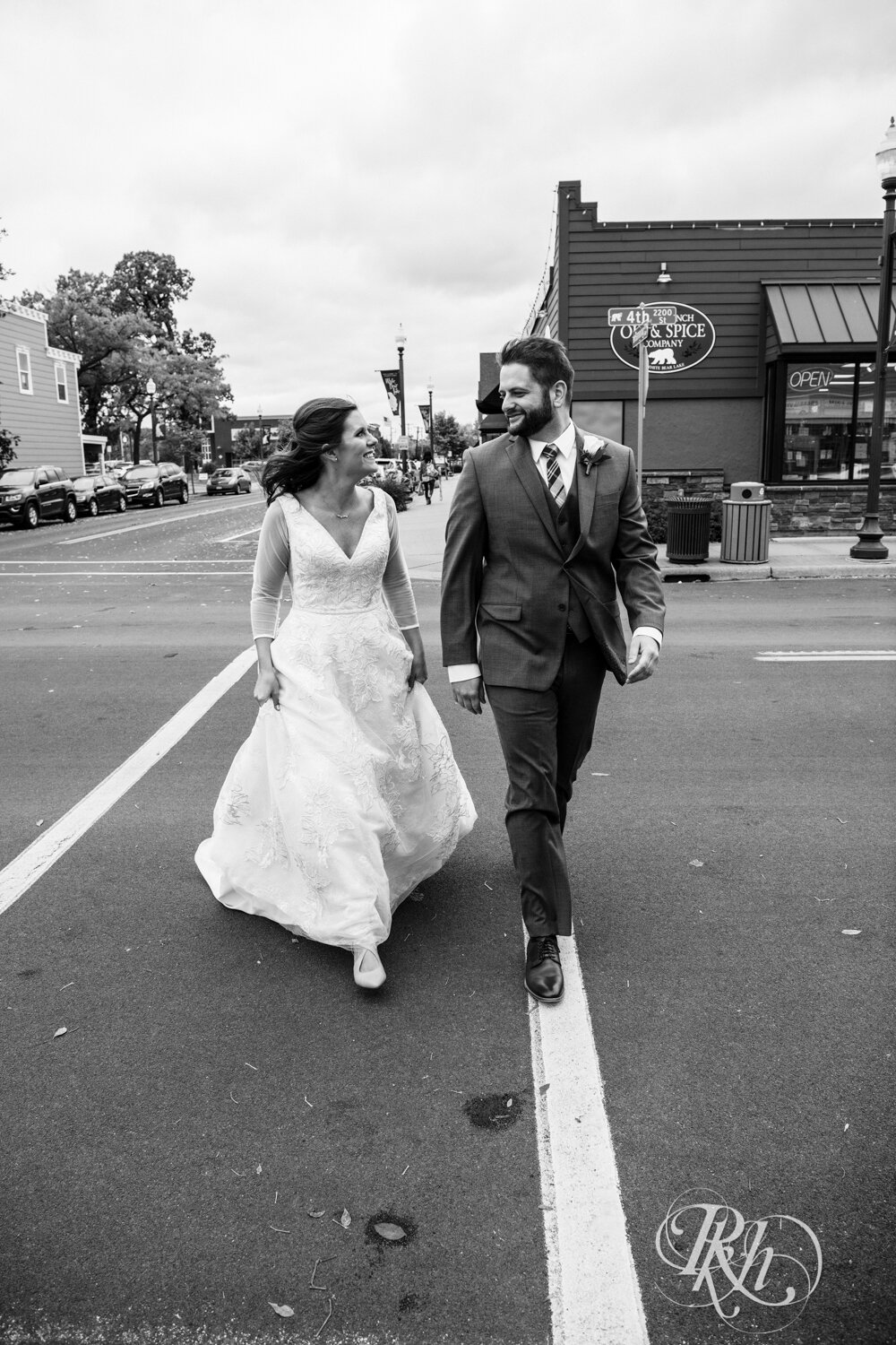 Bride and groom walk in street on wedding day at Kellerman's Event Center in White Bear Lake, Minnesota.
