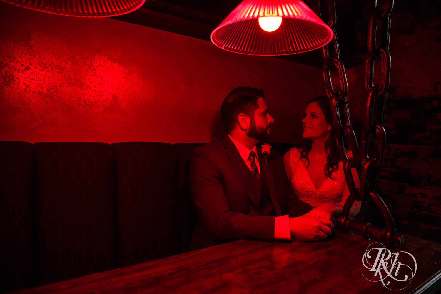 Bride and groom smile at Kellerman's Event Center in White Bear Lake, Minnesota with red light.
