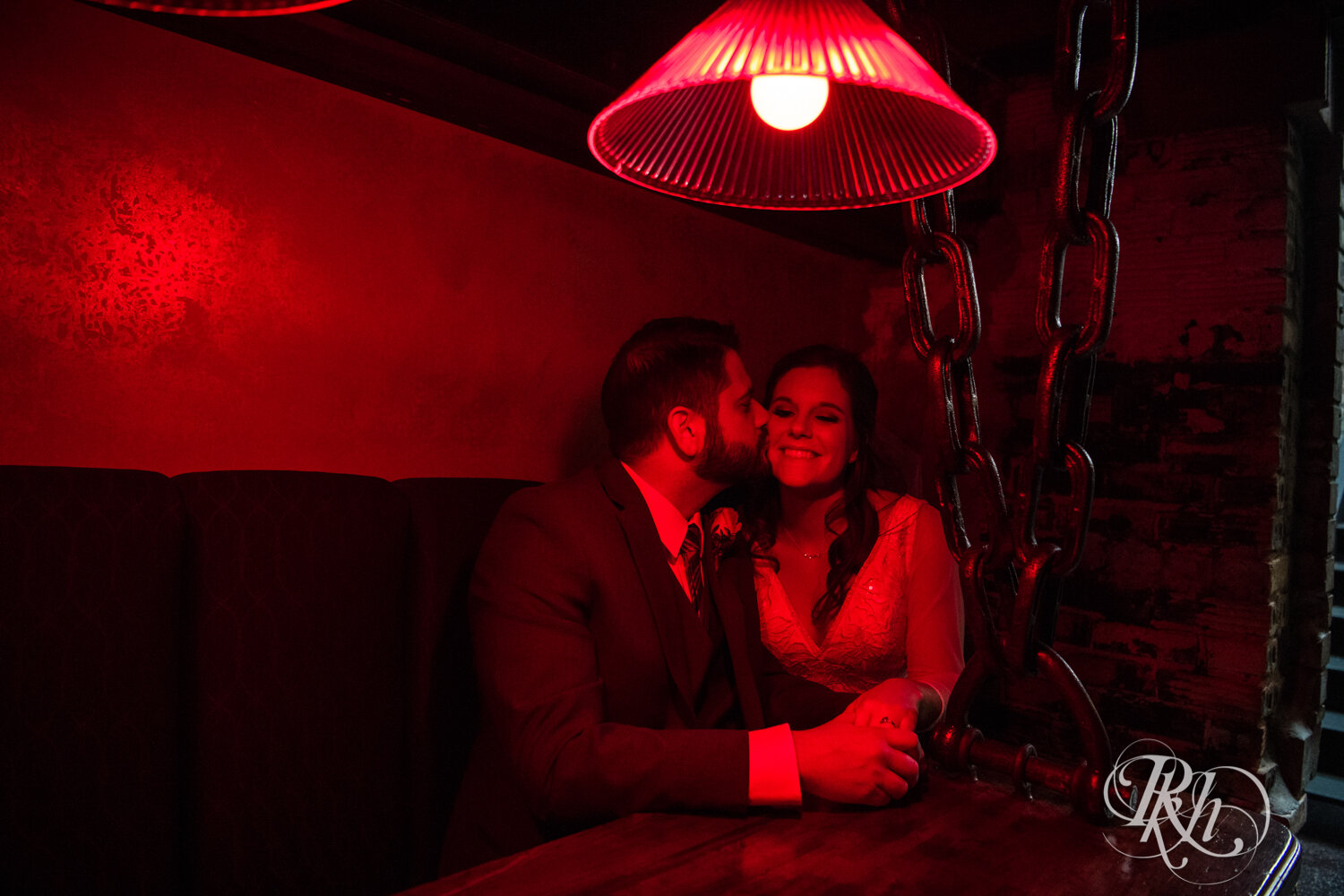 Bride and groom kiss at Kellerman's Event Center in White Bear Lake, Minnesota with red light.
