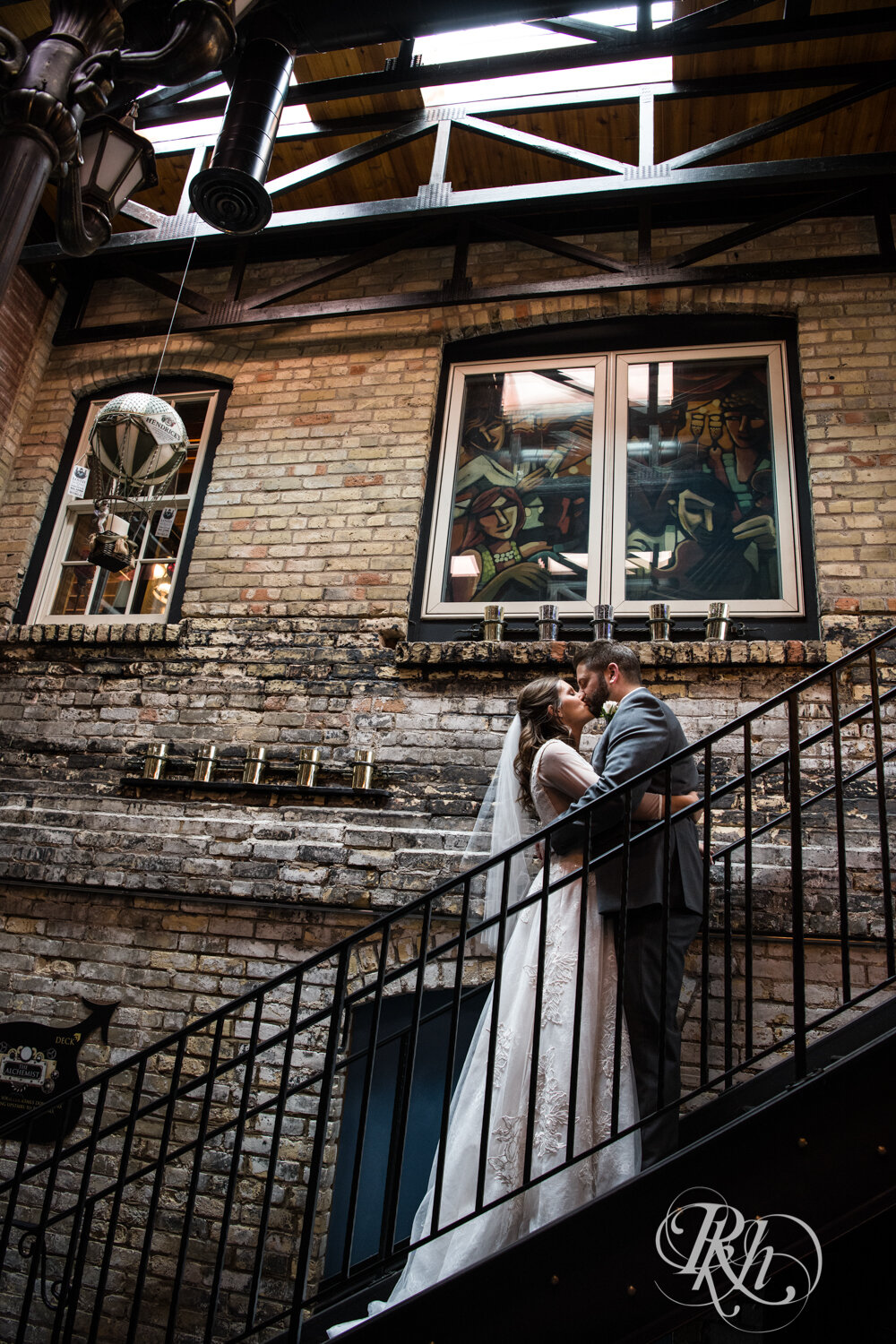 Bride and groom kiss on stairs at Kellerman's Event Center in White Bear Lake, Minnesota.