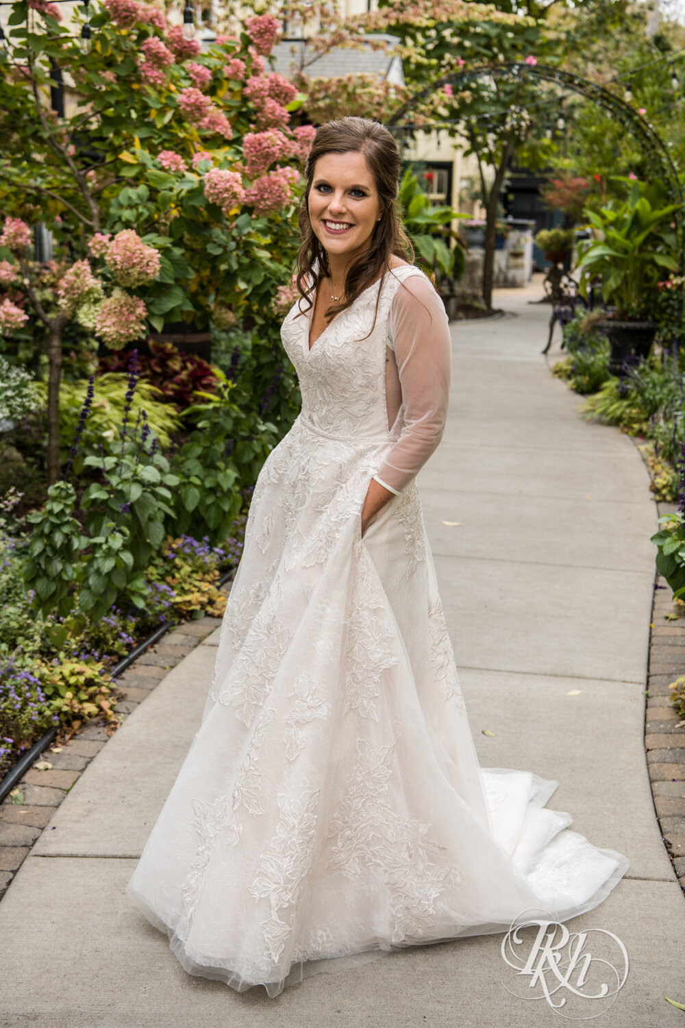 Bride smiles with hands in pockets at Kellerman's Event Center in White Bear Lake, Minnesota.