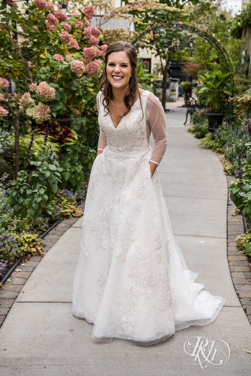 Bride smiles with hands in pockets at Kellerman's Event Center in White Bear Lake, Minnesota.