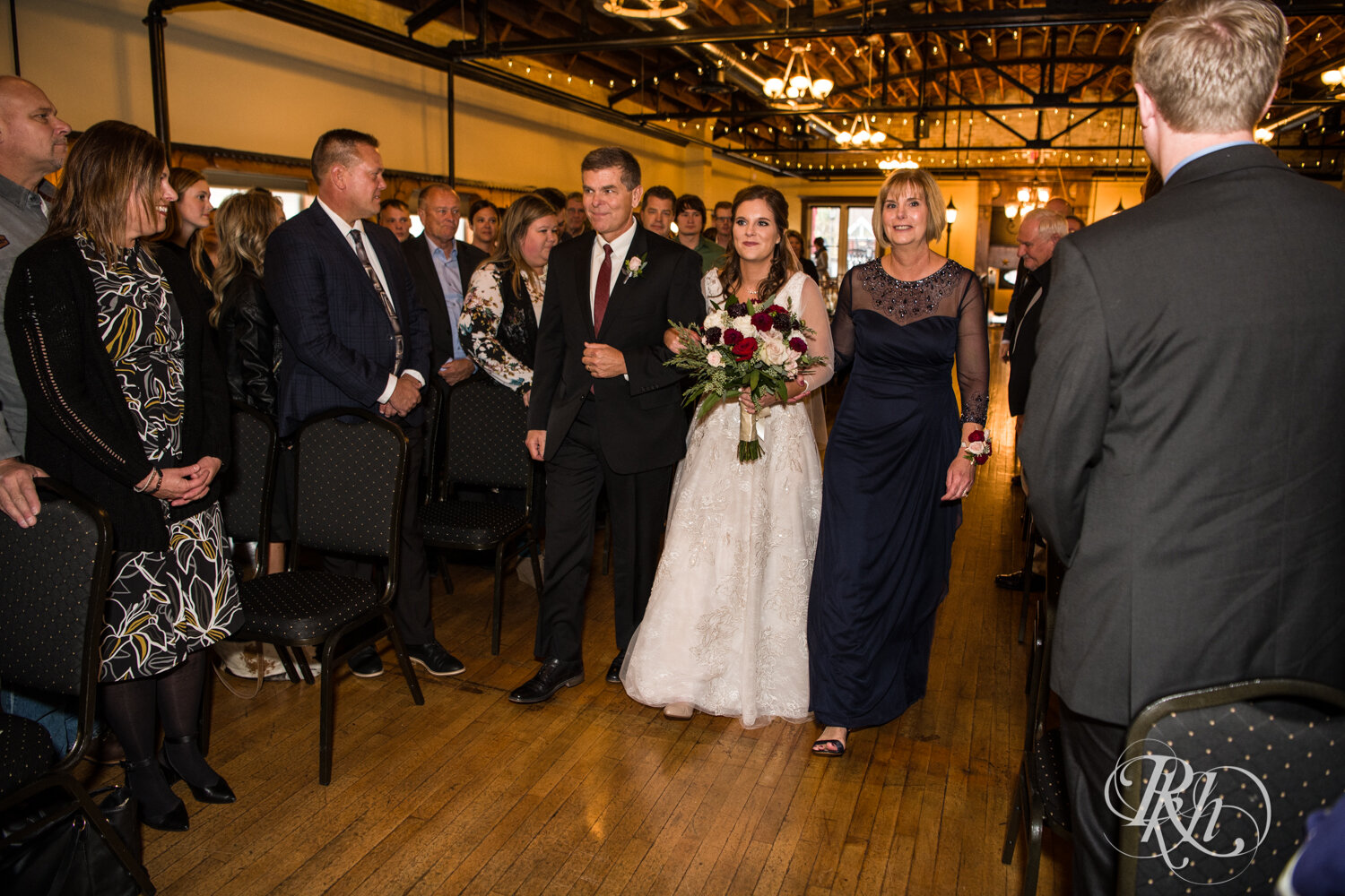 Bride walks down the aisle with mom and dad at Kellerman's Event Center in White Bear Lake, Minnesota.