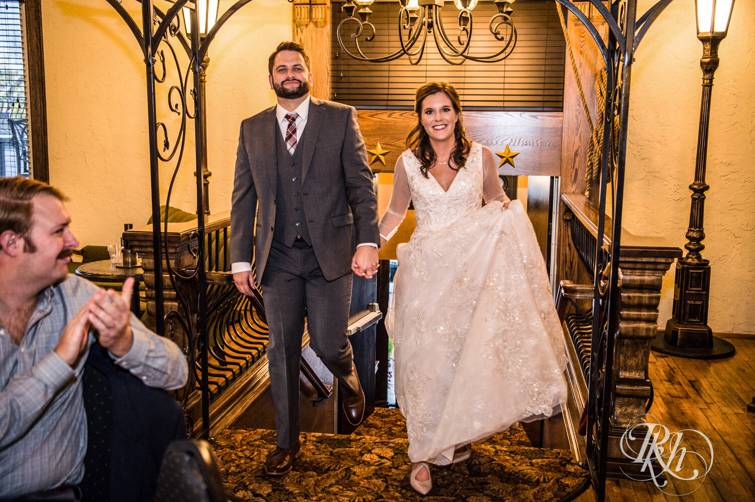 Bride and groom smile entering wedding reception at Kellerman's Event Center in White Bear Lake, Minnesota.