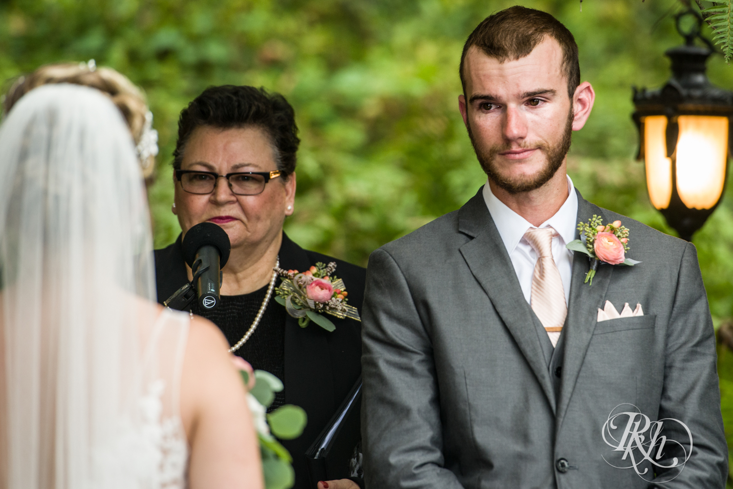 Groom cries seeing bride walk down the aisle Camrose Hill Flower Farm in the rain in Stillwater, Minnesota.
