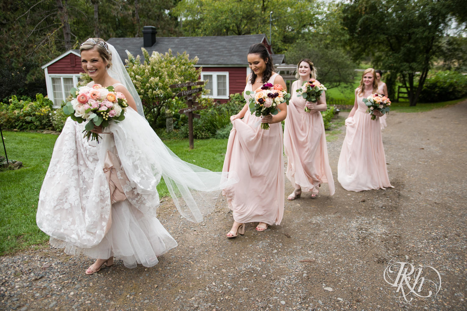 Bridesmaids follow the bride in the rain at Camrose Hill in Stillwater, Minnesota.